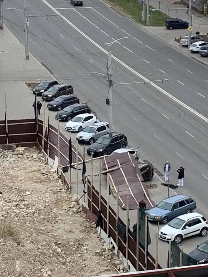 В Кишиневе часть забора снесло ветром на припаркованные машины