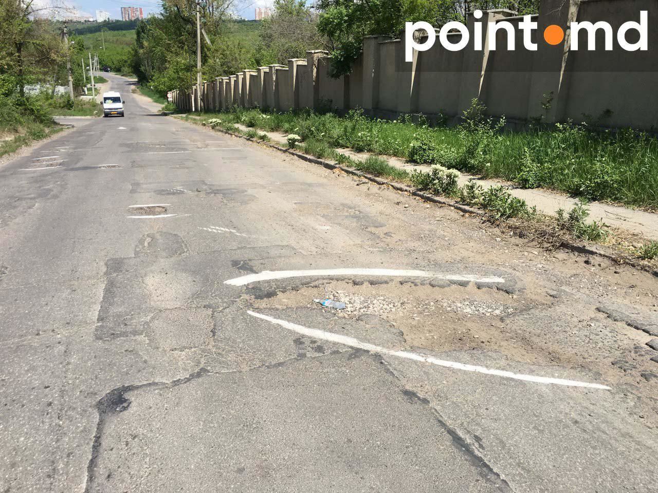 Жители столичной улицы краской обводят ямы на дороге