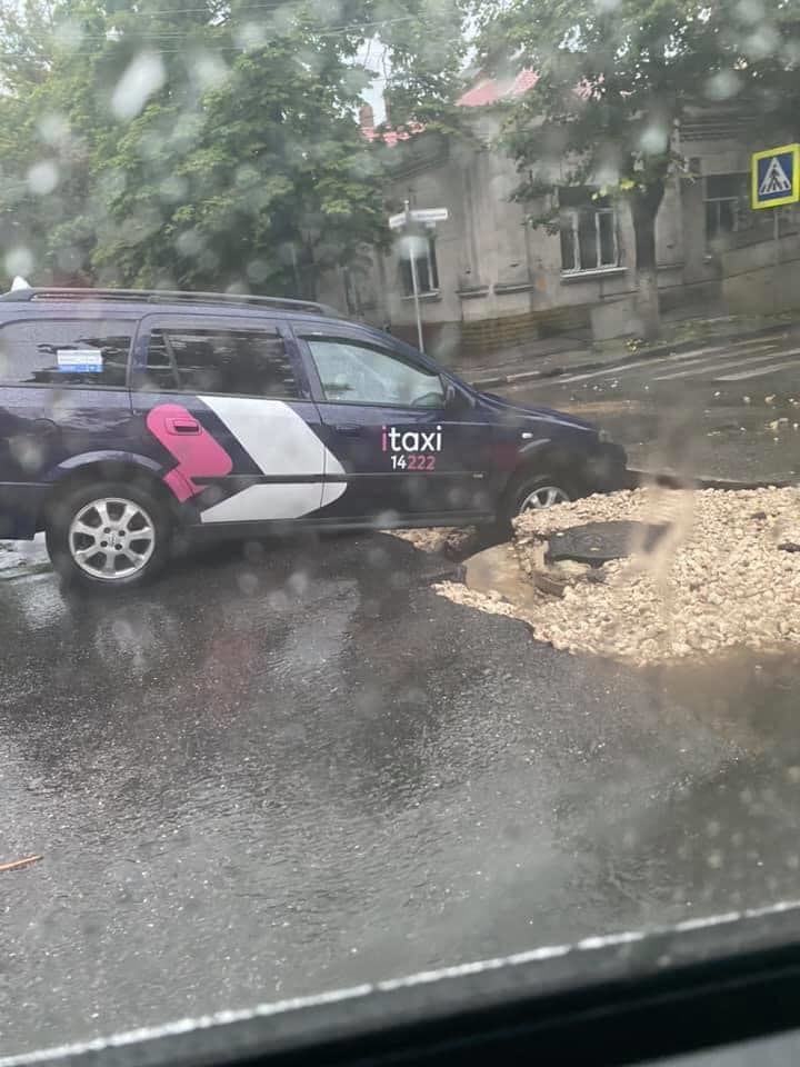 В столице машина службы такси попала в яму посреди дороги