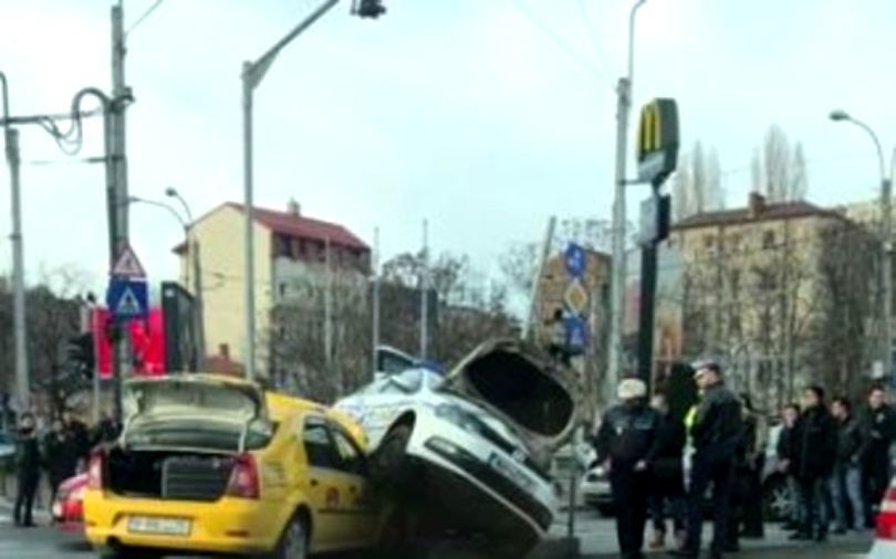 Accident spectaculos: Mașină de poliție cocoțată peste un taxi
