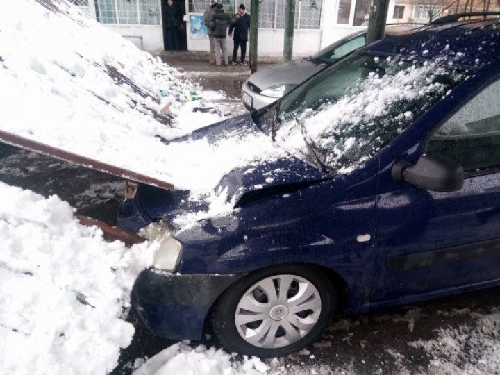 Două maşini, grav avariate, după ce un acoperiş metalic a căzut peste ele