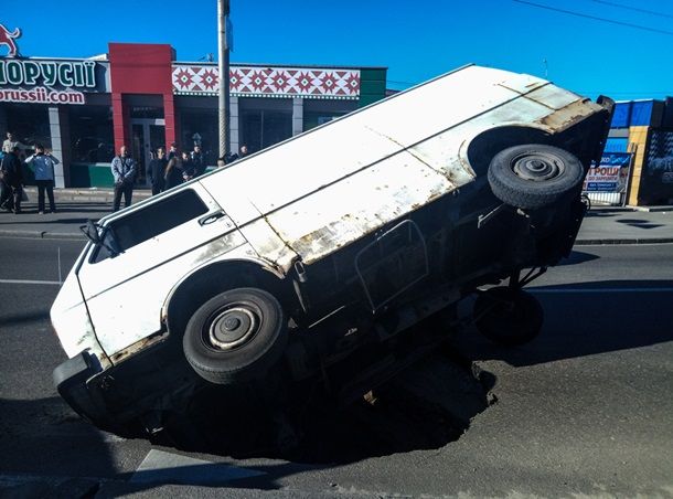 В Киеве микроавтобус "утонул" в яме посреди дороги