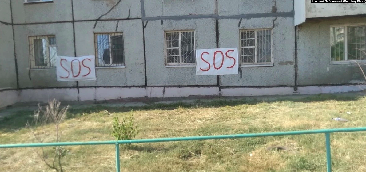 Жители падающего дома в России развесили в окнах плакаты "SOS"