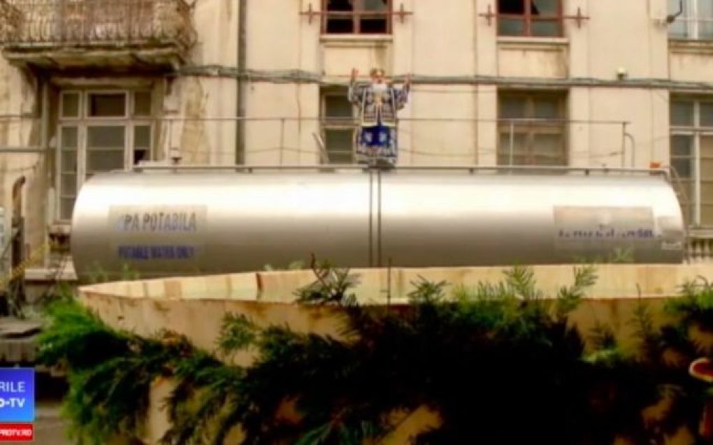 Poza zilei: Un arhiepiscop a urcat pe cisterna cu apă sfinţită